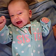 Wyllo is registered to the contest to win money with this photo: baby, bed, blanket, blue_clothing, child, cozy, eyes, face, fists, happy, indoor, infant, lying_down, open_mouth, photograph, polka_dot, portrait, raised_arms, sleepwear, smiling