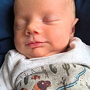 Waylon is registered to the contest to win money with this photo: baby, newborn, sleeping, onesie, clothing, face, infant, peaceful, cute, child, portrait, soft, skin, blanket, bed, resting, nature_print, animal_print, blue_background, closeup
