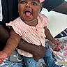 baby, child, girl, pink_bow, pink_top, denim_jeans, ripped_jeans, person, hand, smiling, happy, tongue_out, indoor, lap, clothing, fashion, cute, joyful, skin, headband