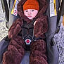 Brody joined the competition — help win amazing prizes! baby, child, car_seat, bear_costume, orange_hat, fuzzy_clothing, straps, indoor, car_seat_warning_labels, cute, infant, young_child, portrait, sitting, warm_clothing, plush, face, wide_eyes, baby_clothes, hat