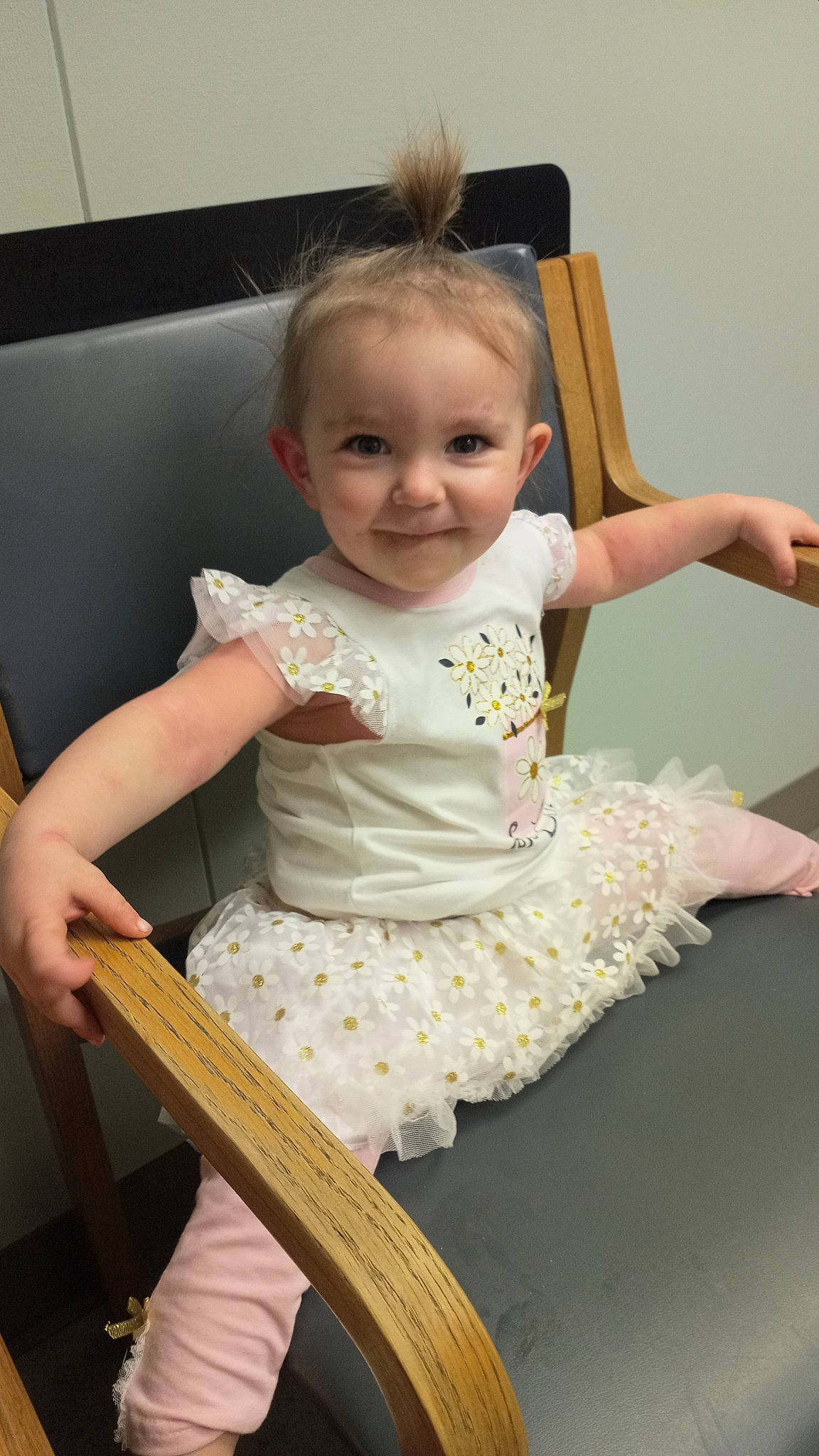 Lylah is registered to the contest to win money with this photo: arm, baby, baby_toddler_clothing, blond, chair, cheek, child, day_dress, embellishment, eye, finger, fun, hand, happy, human_body, joy, person, sitting, skin, sleeve