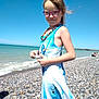 beach, beachwear, bodypart, child, clothing, coast, dress, eveningdress, face, female, finger, formalwear, girl, hand, head, nature, pebble, person, photography, portrait