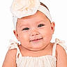 Ariella is registered to the contest to win money with this photo: baby, infant, smiling, headband, flower, cream_color, dress, cute, portrait, child, face, skin, arms, studio, white_background, happy, young, person, closeup, fashion