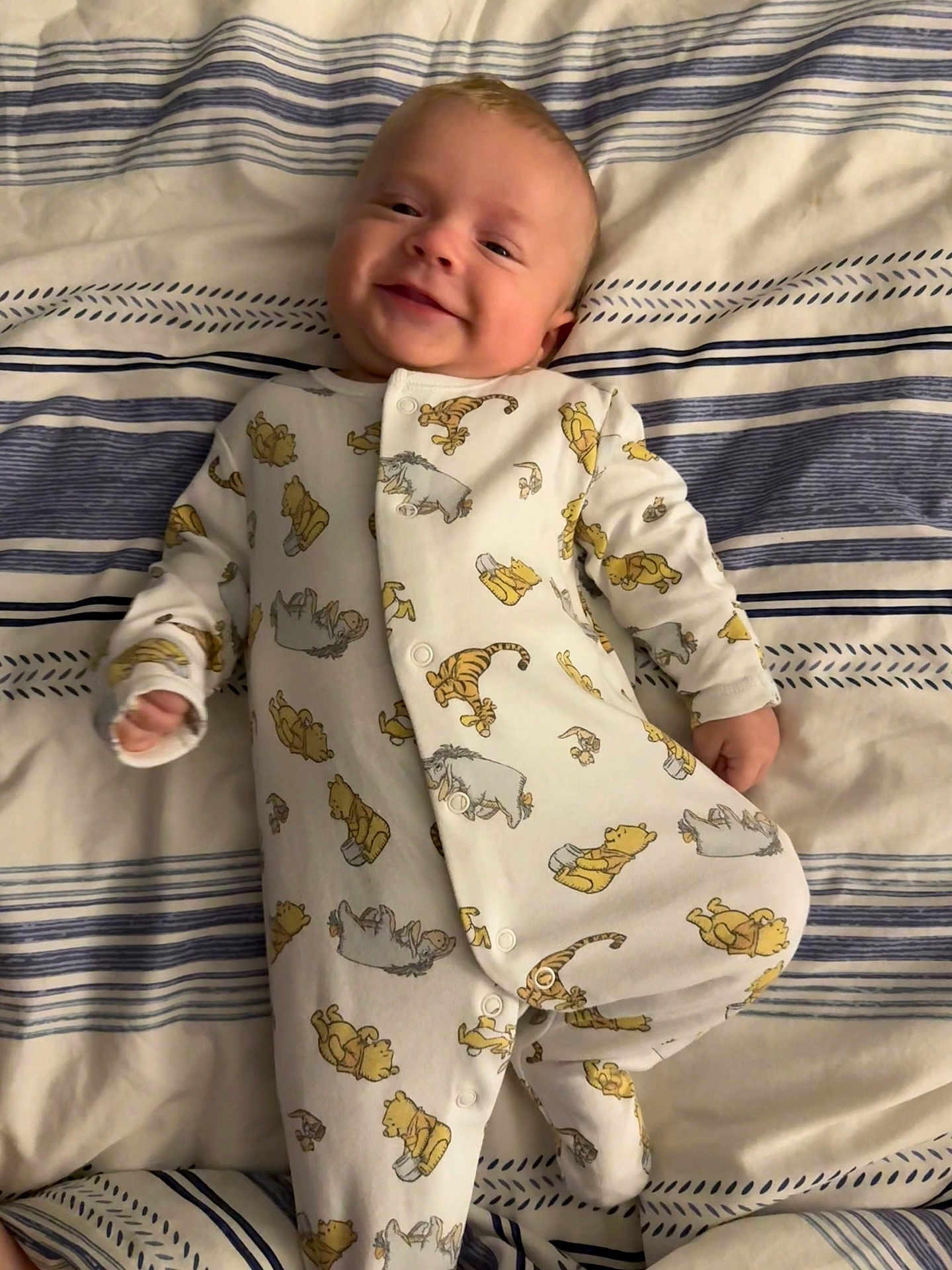 Oscar joined the competition — help win amazing prizes! baby, infant, smile, onesie, winnie_the_pooh, bed, blanket, striped, sleepwear, child, cute, comfort, lying_down, happy, portrait, young_child, indoors, soft_lighting, fabric, cozy