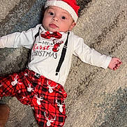 Jaxon is registered to the contest to win money with this photo: baby, infant, christmas, holiday, santa_hat, red_bow_tie, reindeer_pattern, plaid_pants, sock, carpet, cute, festive, lying_down, indoors, portrait, child, celebration, seasonal_clothing, smiling, person