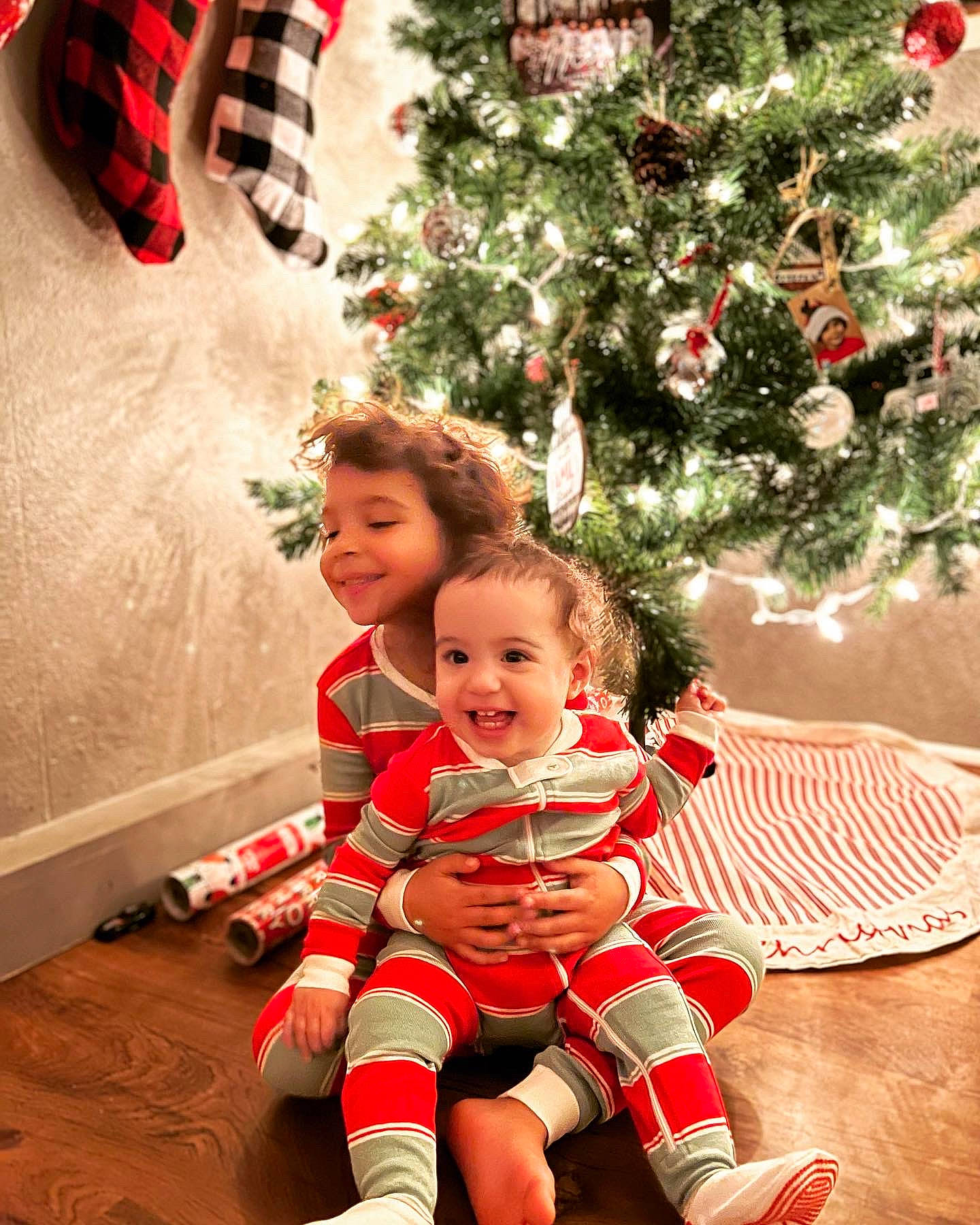 Opal Rose is registered to the contest to win money with this photo: baby, baby_toddler_clothing, christmas_decoration, christmas_ornament, christmas_tree, happy, holiday_ornament, joy, leaf, organ, ornament, person, photograph, plant, red, shoe, smile, standing, toddler, tree