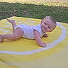 Tristan joined the competition — help win amazing prizes! baby, child, infant, outdoor, grass, yellow_mat, white_onesie, lying_down, happy, smiling, face, skin, head, arms, legs, foot, sunlight, nature, playtime, daylight