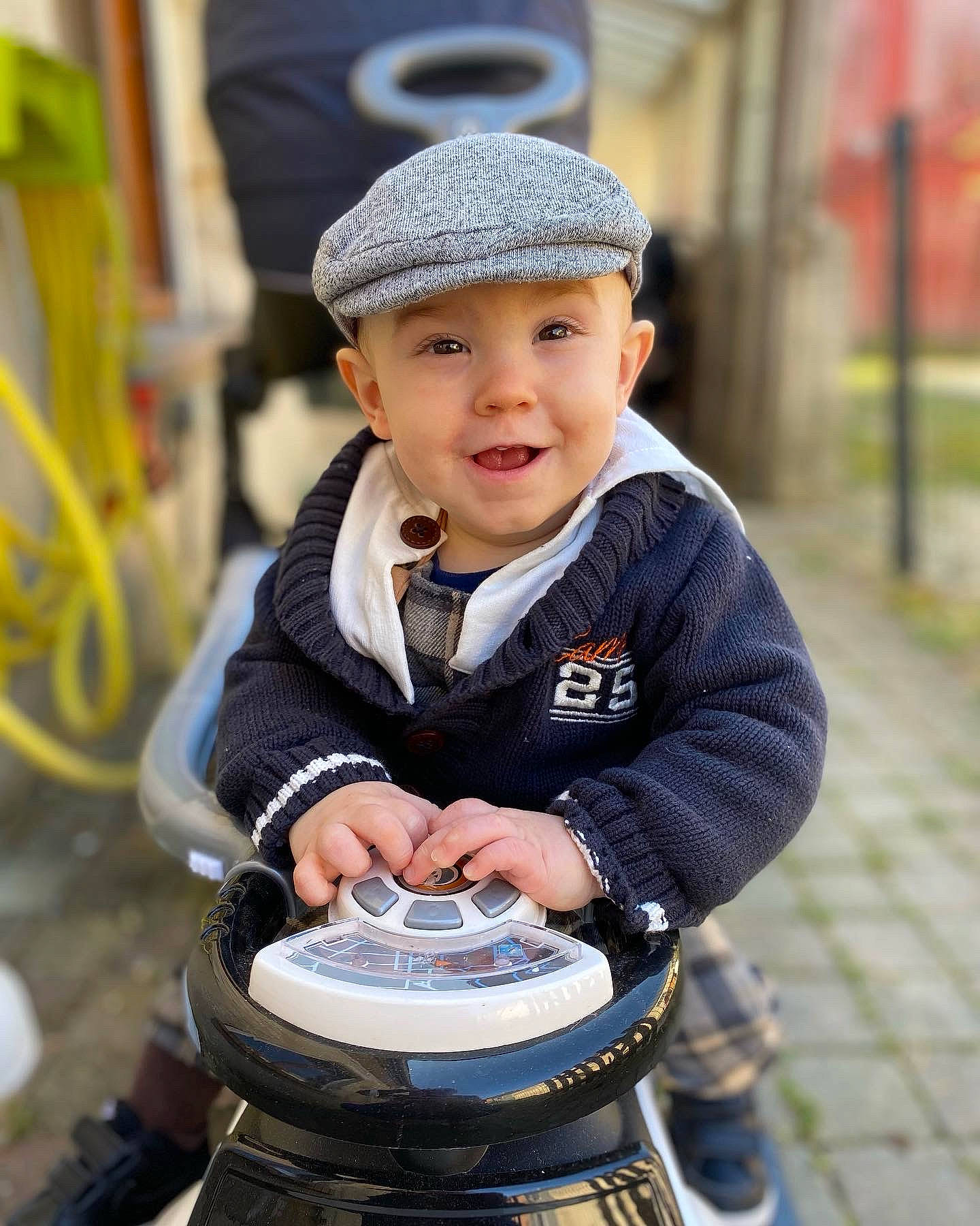 Aaron participe au concours pour gagner de l'argent avec cette photo : automotive_wheel_system, baby_carriage, baby_products, beanie, camera, cap, eye, flash_photography, fun, grass, happy, hat, headwear, jacket, person, personal_protective_equipment, plant, recreation, sitting, smile