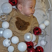 Juliann participe au concours pour gagner de l'argent avec cette photo : baby, bear_design, blanket, child, christmas_ornaments, clear_balls, cozy, cute, face, head, holiday_decor, indoors, infant, peaceful, red_balls, resting, sleeping, soft_texture, sweater, white_balls