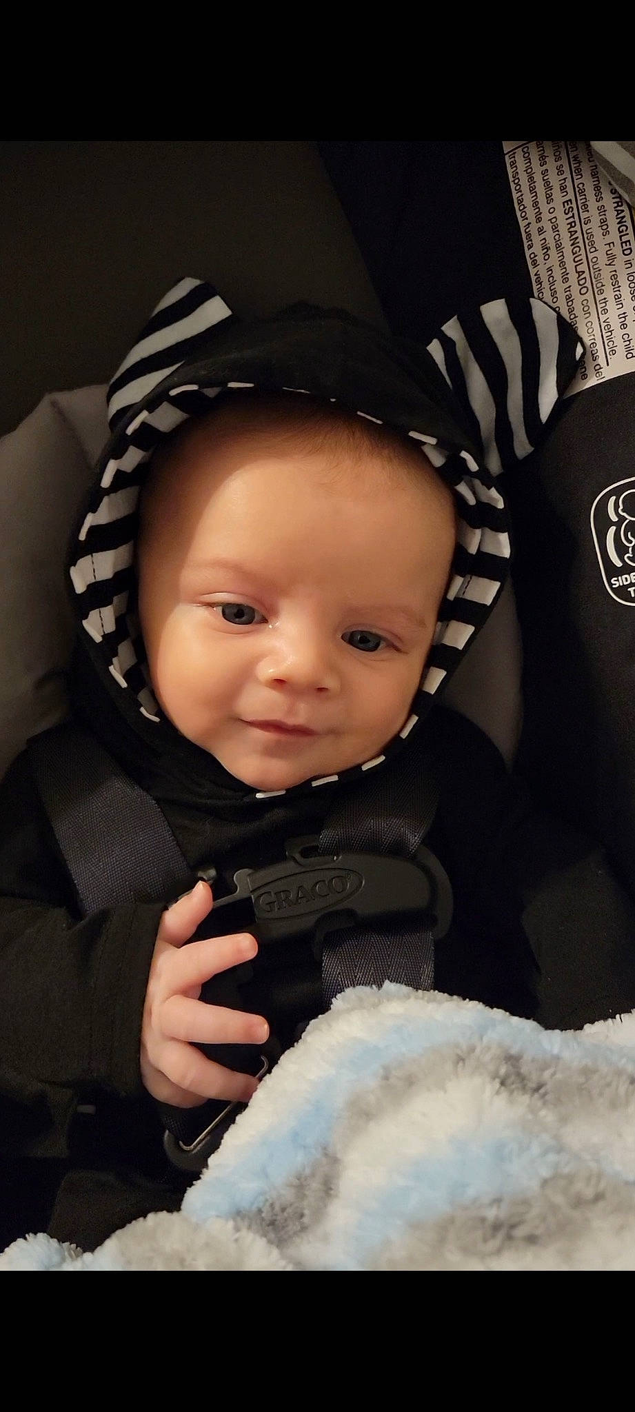 Ares is registered to the contest to win money with this photo: baby, baby_carriage, baby_toddler_clothing, black, cap, cheek, comfort, cool, eye, eyebrow, finger, flash_photography, gesture, happy, headgear, outerwear, person, skin, sleeve, smile