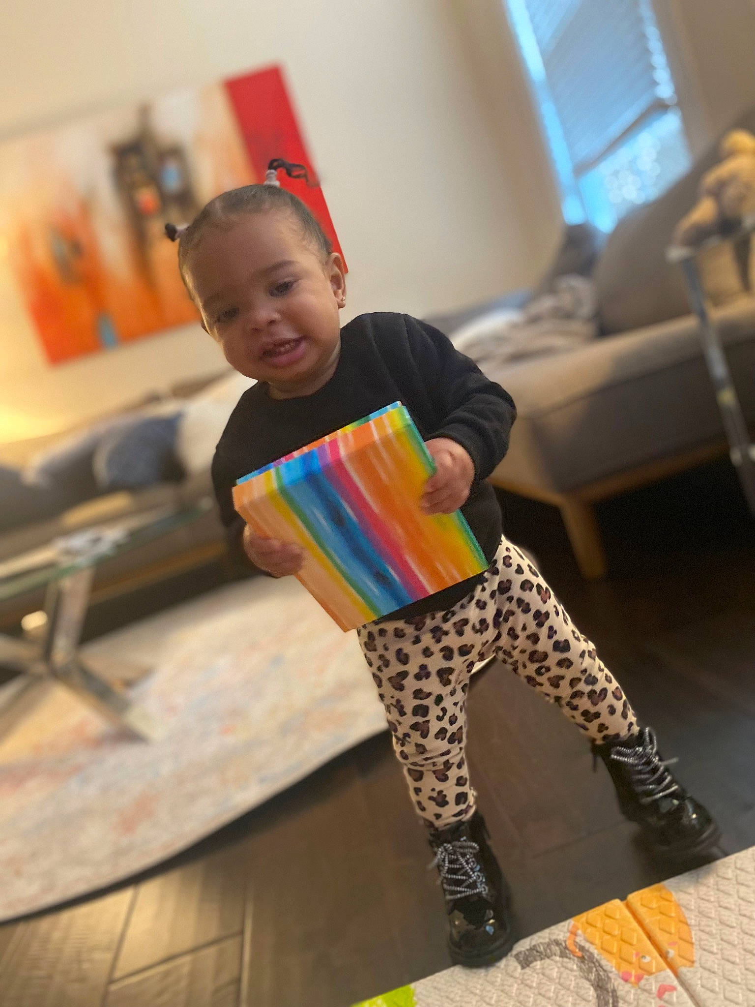 Ariana is registered to the contest to win money with this photo: child, eyewear, fashion_accessory, fashion_design, flooring, fun, happy, human_leg, knee, pattern, person, room, sitting, sleeve, sock, sportswear, standing, t_shirt, thigh, toddler