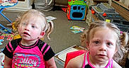 Emily And Allison joined the competition — help win amazing prizes! blonde_hair, books, casual_clothing, chairs, children, clutter, colorful, girls, home, indoor, photograph, pigtails, playroom, portrait, siblings, sitting, smiling, toddlers, toy_kitchen, toys