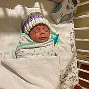 Emily And Allison is registered to the contest to win money with this photo: newborn, baby, sleeping, hospital, bassinet, swaddled, knit_cap, pacifier, medical_monitor, blanket, crib, infant, portrait, indoors, peaceful, resting, face, head, healthcare, photography