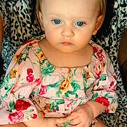 Eden is registered to the contest to win money with this photo: apparel, baby, blue_eyes, child, closeup, cute, face, fashion, floral_clothing, hands, indoor, infant, leopard_print, pattern, person, portrait, serious_expression, sitting, skin, young_child