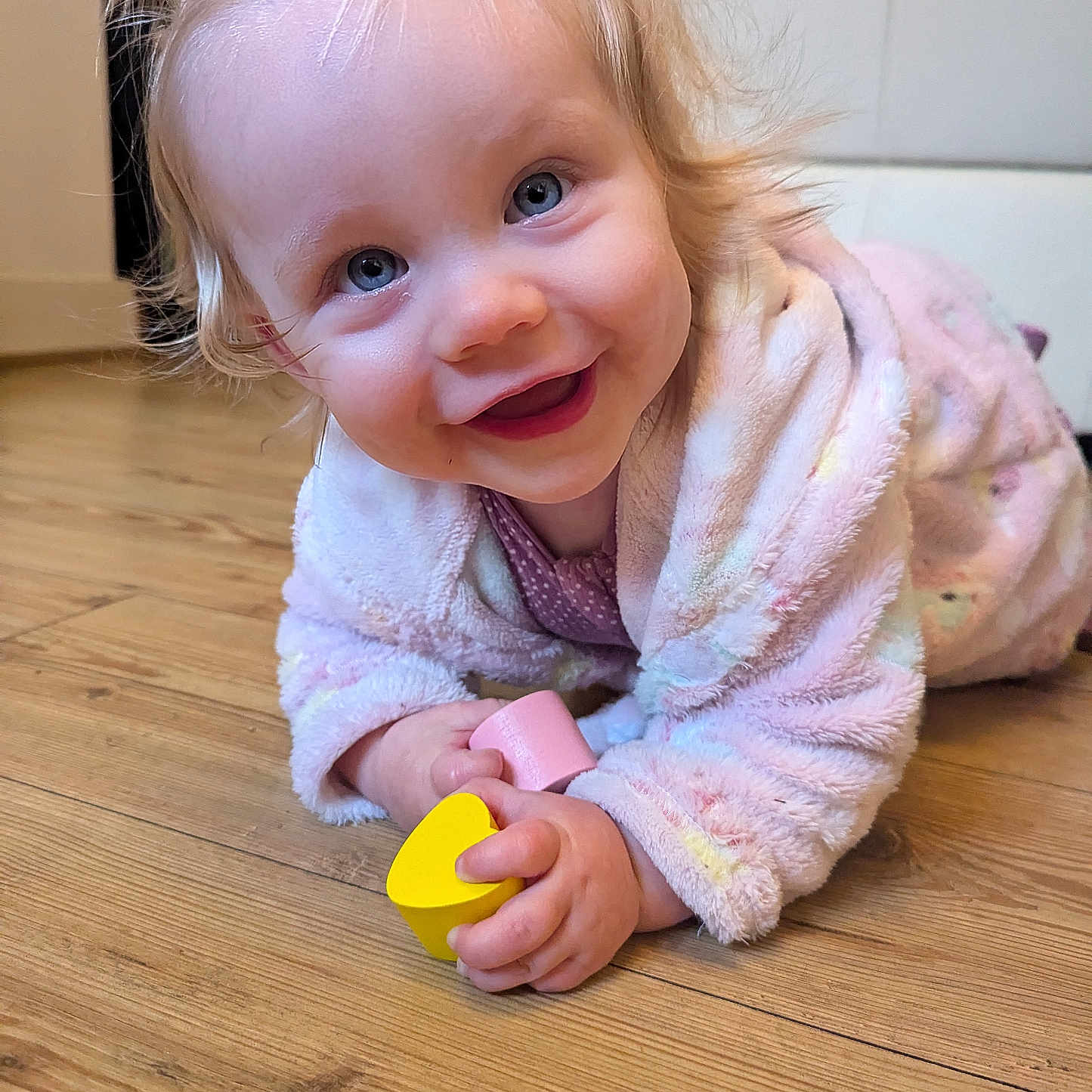 Rosalie is registered to the contest to win money with this photo: baby, bodypart, clothing, face, finger, hand, happy, hardwood, head, indoors, interiordesign, knitwear, person, photography, plywood, portrait, sitting, smile, sweater, wood