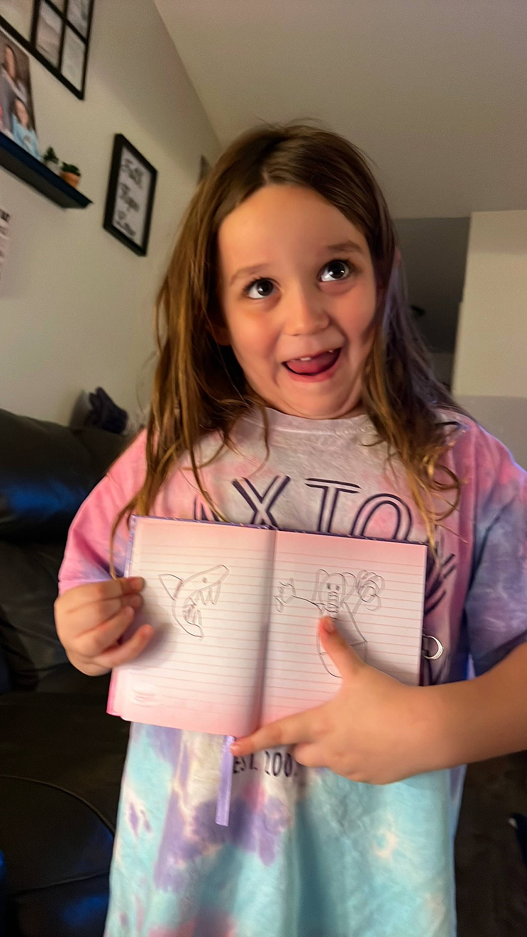 Mckenzie is registered to the contest to win money with this photo: child, couch, event, eyelash, finger, fun, handwriting, happy, joy, paper, paper_product, person, picture_frame, room, sitting, smile, t_shirt
