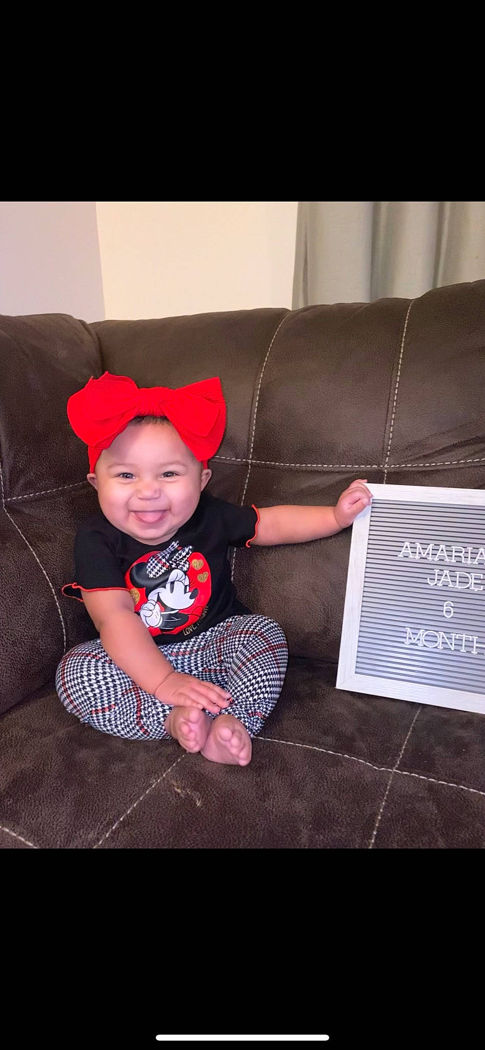 Amariana is registered to the contest to win money with this photo: baby, baby_toddler_clothing, carmine, comfort, couch, electronic_device, flooring, happy, headwear, joy, lap, living_room, pattern, person, room, sitting, sleeve, smile, snapshot, sock