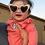 Chloe is registered to the contest to win money with this photo: child, baby, sunglasses, heart_shaped_sunglasses, pink_clothing, smile, outdoor, sky, person, hand, arm, holding, portrait, happy, cute, toddler, fashion, accessory, backyard, ruffle_sleeve