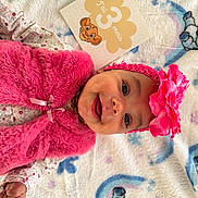Inaya participe au concours pour gagner de l'argent avec cette photo : baby, infant, smiling, pink_vest, headband, flower, blanket, animal_pattern, rainbow, card, milestone, cute, happy, lying_down, child, portrait, soft_texture, clothing, celebration, indoors