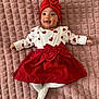 Inaya participe au concours pour gagner de l'argent avec cette photo : baby, infant, smiling, red_turban, red_dress, white_tights, heart_pattern, blanket, lying_down, cute, happy, child, portrait, indoor, fashion, headwear, one_person, young_child, soft_texture, baby_clothes