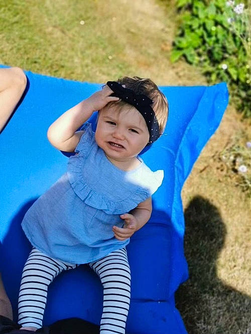 Naomie participe au concours pour gagner de l'argent avec cette photo : azure, baby_toddler_clothing, child, electric_blue, eye, fun, grass, happy, head, headwear, human_body, leg, leisure, outdoor_play_equipment, people_in_nature, person, playground, public_space, recreation, sitting