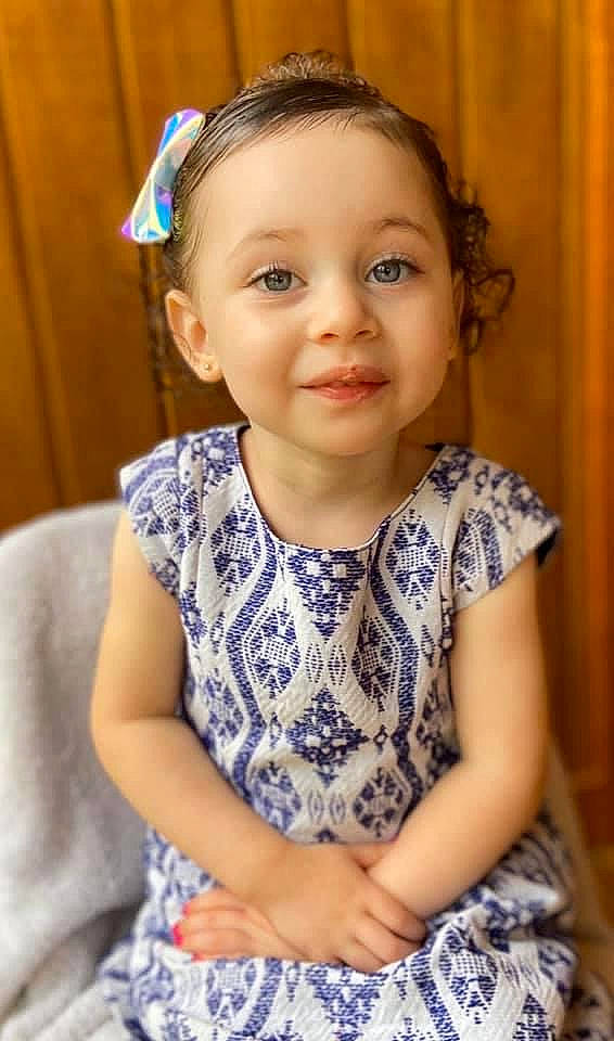 Emma is registered to the contest to win money with this photo: baby, cheek, child, child_model, hair, hair_accessory, headband, headgear, headpiece, joy, person, sitting, smile, toddler