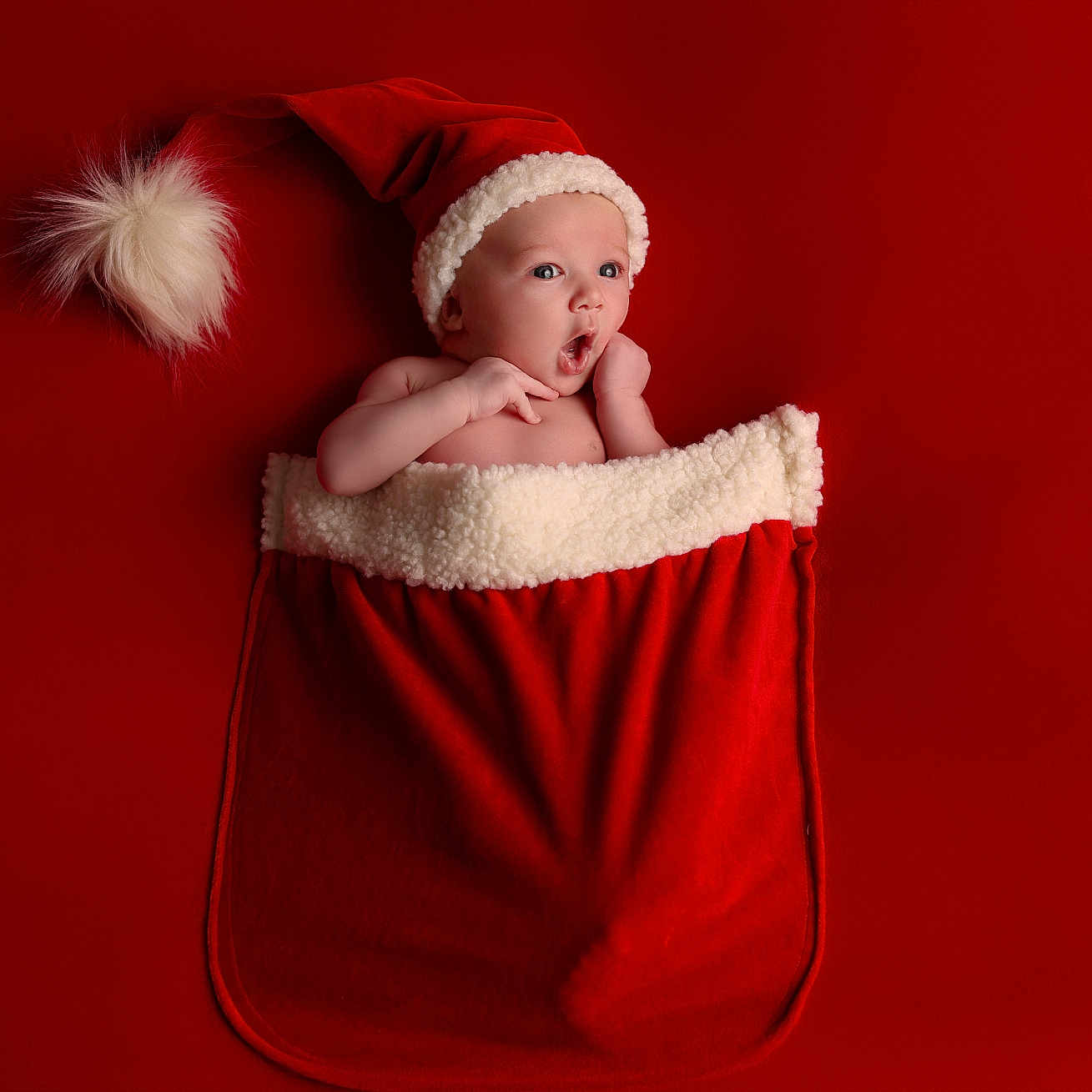 Sohan participe au concours pour gagner de l'argent avec cette photo : baby, santa_hat, christmas_stocking, red_background, holiday, festive, cute, infant, expression, surprised, child, portrait, celebration, warm, cozy, seasonal, christmas, decoration, soft_texture, happy