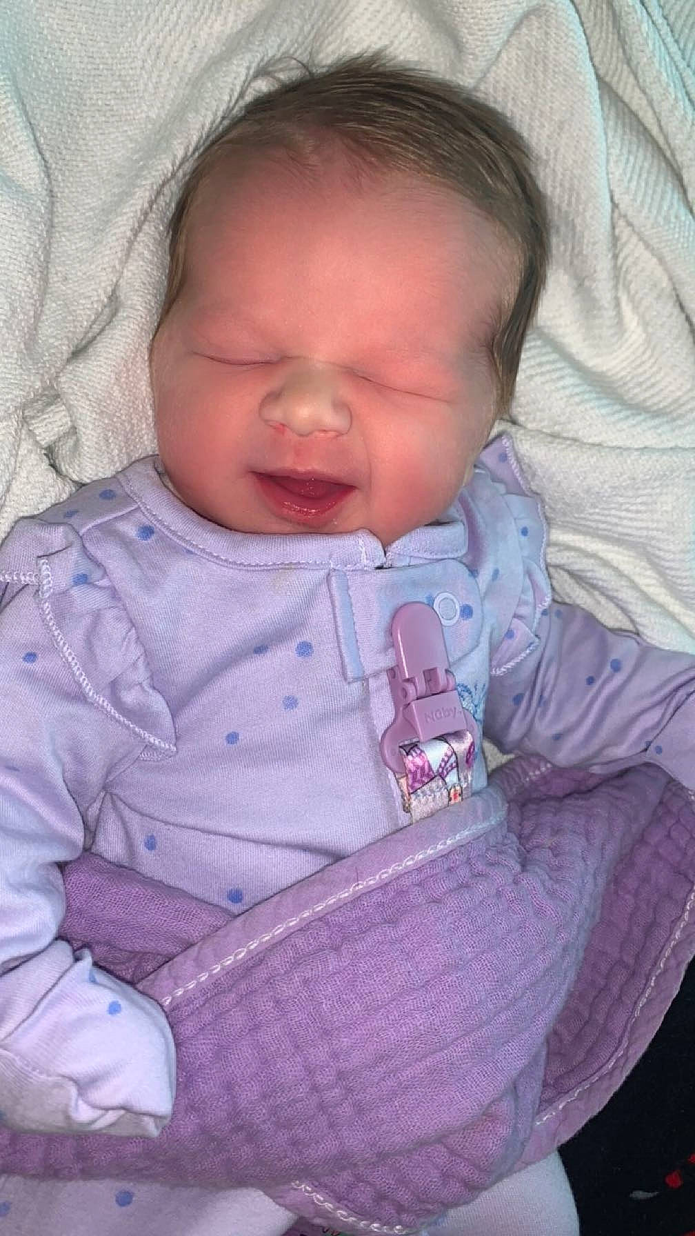 Mariana is registered to the contest to win money with this photo: baby, baby_toddler_clothing, cheek, chin, comfort, eye, eyebrow, facial_expression, finger, head, iris, lip, mouth, nose, person, pink, product, purple, skin, sleeve