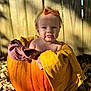 baby, pumpkin, blanket, bow, outdoor, autumn, fall_leaves, fence, sunlight, child, cute, tongue_out, nature, seasonal, portrait, baby_headband, orange, yellow, purple, playful