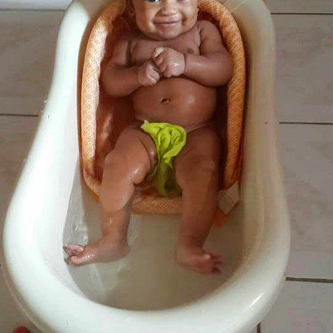 Emilio Whyte is registered to the contest to win money with this photo: baby, bath_time, bathtub, child, cute, floor, foot, green_cloth, happy, indoor, infant, person, playful, sitting, skin, smile, tile, toes, water, young