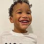Tidiane a rejoint le concours — aidez-le/la à gagner de superbes lots ! child, smiling, curly_hair, teeth, white_wall, white_tshirt, nasa_logo, portrait, closeup, happy, cute, cheerful, indoors, young_child, face, eyes, skin, head, shoulders, gap_tooth_smile