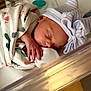 newborn, baby, sleeping, blanket, hat, bow, hospital, bassinet, infant, hand, face, cozy, rest, cute, striped, soft_lighting, patterned, wrapped, indoors, peaceful