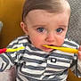 Thomas is registered to the contest to win money with this photo: toddler, child, blue_eyes, striped_shirt, toothbrush, brushing_teeth, cute, indoor, portrait, young_child, baby, person, sitting, hand, face, furniture, couch, clothing, expression, multitasking