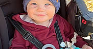 Liam joined the competition — help win amazing prizes! baby_toy, blanket, child, clothing, cute, daylight, face, happy, hat, infant, knit_hat, outdoor, person, pom_poms, portrait, seatbelt, smile, stroller, toddler, warm_clothing