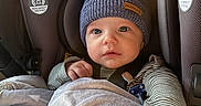Liam joined the competition — help win amazing prizes! baby, blanket, blue_hat, car_seat, child, clothing, cozy, cute, face, hand, hat, indoors, infant, knit_hat, pom_poms, portrait, safety_strap, seated, striped_clothing, young_child