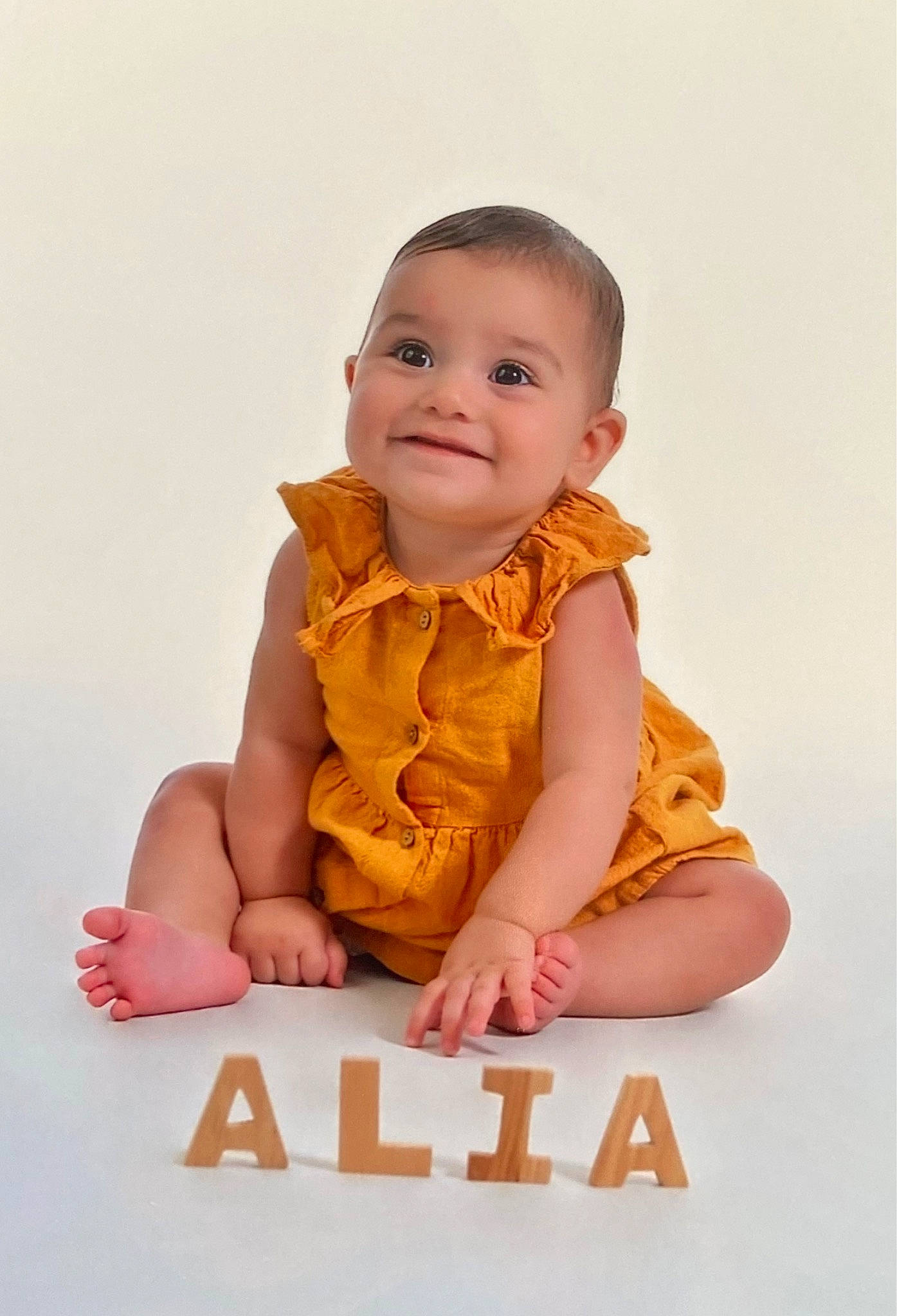 Alia participe au concours pour gagner de l'argent avec cette photo : baby, baby_toddler_clothing, cheek, child, collar, face, finger, flash_photography, flooring, gesture, happy, joy, nail, peach, person, portrait_photography, sitting, sleeve, smile, t_shirt