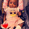 adorable, baby, car_seat, child, clothing, comfortable, cute, happy, headrest, heart_emoji, indoor, infant, patterned_seat, pink, portrait, seatbelt, smiling_sun, socks, soft_lighting, young