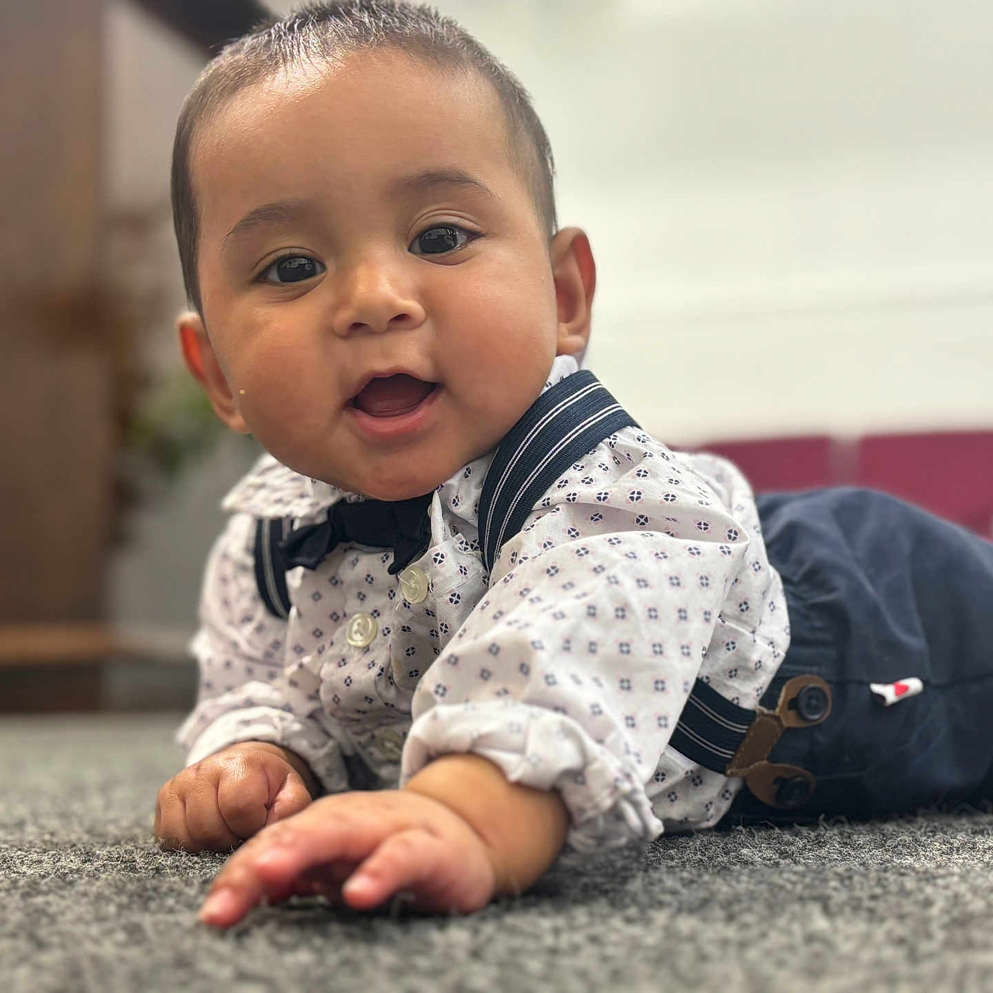 Natanael is registered to the contest to win money with this photo: baby, background_blur, bow_tie, carpet, child, clothing, crawling, cute, face, focus, hands, happy, indoors, infant, person, portrait, shirt, smiling, suspenders, young_child
