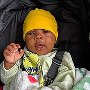 Ace joined the competition — help win amazing prizes! baby, child, yellow_hat, blanket, car_seat, clothing, hand, face, person, infant, cute, portrait, cozy, straps, smiling, indoors, warm, happy, expression, resting