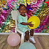 Erza joined the competition — help win amazing prizes! toddler, child, balloon, yellow_balloon, pink_balloon, blue_balloon, chair, wooden_floor, colorful_backdrop, foil_backdrop, party_decorations, cartoon_sharks, purple_stars, smiling, shorts, tshirt, white_shoes, braided_hair, indoor, celebration