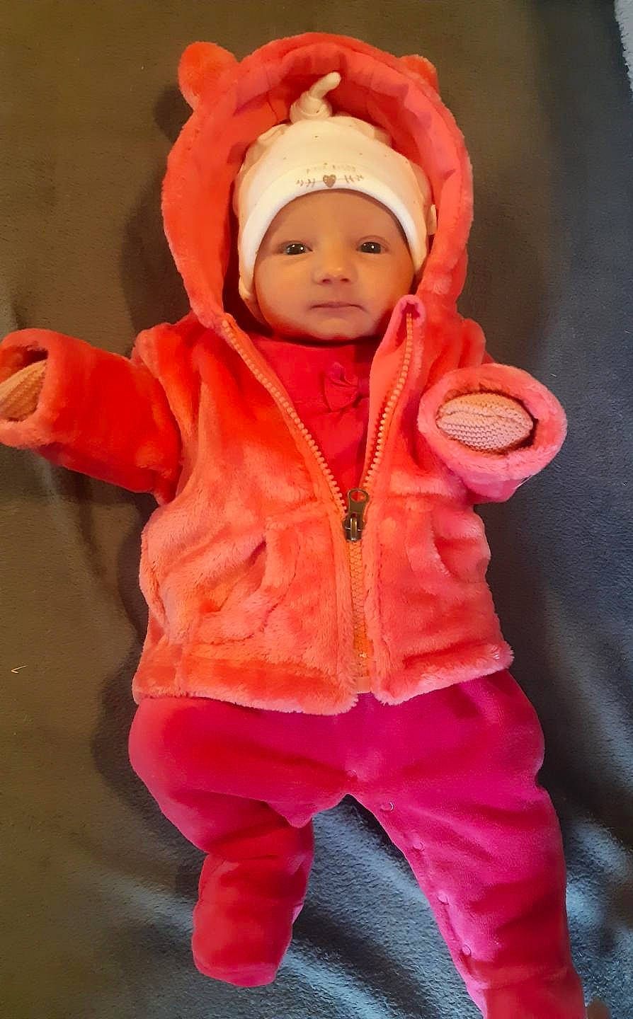 Alix participe au concours pour gagner de l'argent avec cette photo : baby, baby_products, baby_toddler_clothing, cheek, child, costume, eye, face, fur, head, headgear, headwear, hood, human_body, jacket, orange, outerwear, peach, person, pink