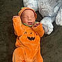 Nicolas is registered to the contest to win money with this photo: baby, infant, costume, halloween, pumpkin, orange, sleeping, cute, plush_toy, stuffed_animal, soft, blanket, child, clothing, indoors, cozy, resting, face, headwear, smile