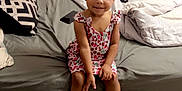 Journey is registered to the contest to win money with this photo: child, girl, bed, pillow, blanket, slippers, animal_slippers, dress, indoor, floor, smile, hair, pigtails, furniture, room, toy, footwear, person, cute, cozy