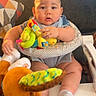 Ezekiel is registered to the contest to win money with this photo: baby, infant, walker, plush_toy, colorful_toy, socks, couch, pillow, blanket, home_interior, child, cute, seated, face, indoor, person, soft_toy, furniture, happy, curious