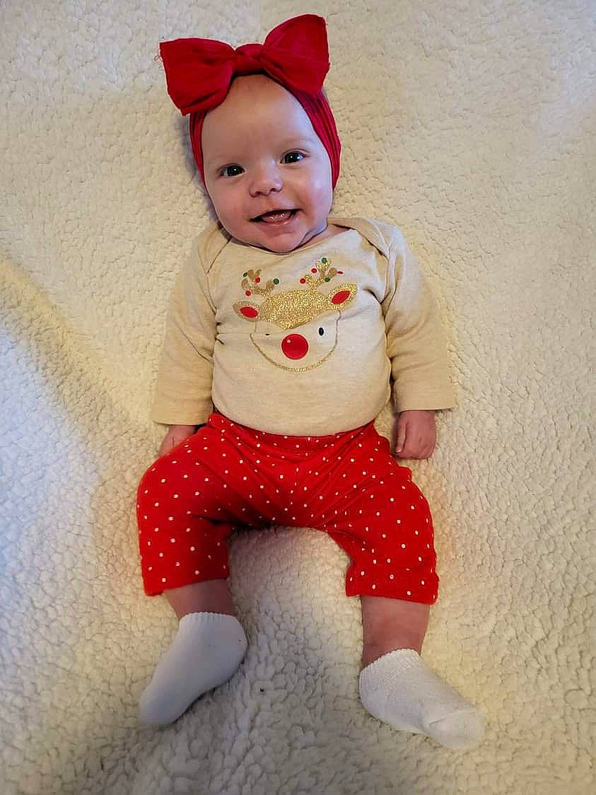 Annalee is registered to the contest to win money with this photo: arm, baby, baby_toddler_clothing, cap, carmine, child, clothing, costume_hat, doll, face, happy, head, headwear, human_body, joy, leg, outerwear, pattern, person, skin