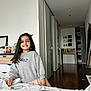 Aadya is registered to the contest to win money with this photo: child, girl, smiling, bedroom, bed, sweatshirt, skirt, paper_craft, floor, furniture, dresser, photograph, mirror, hallway, door, wooden_floor, indoor, person, long_hair, happy