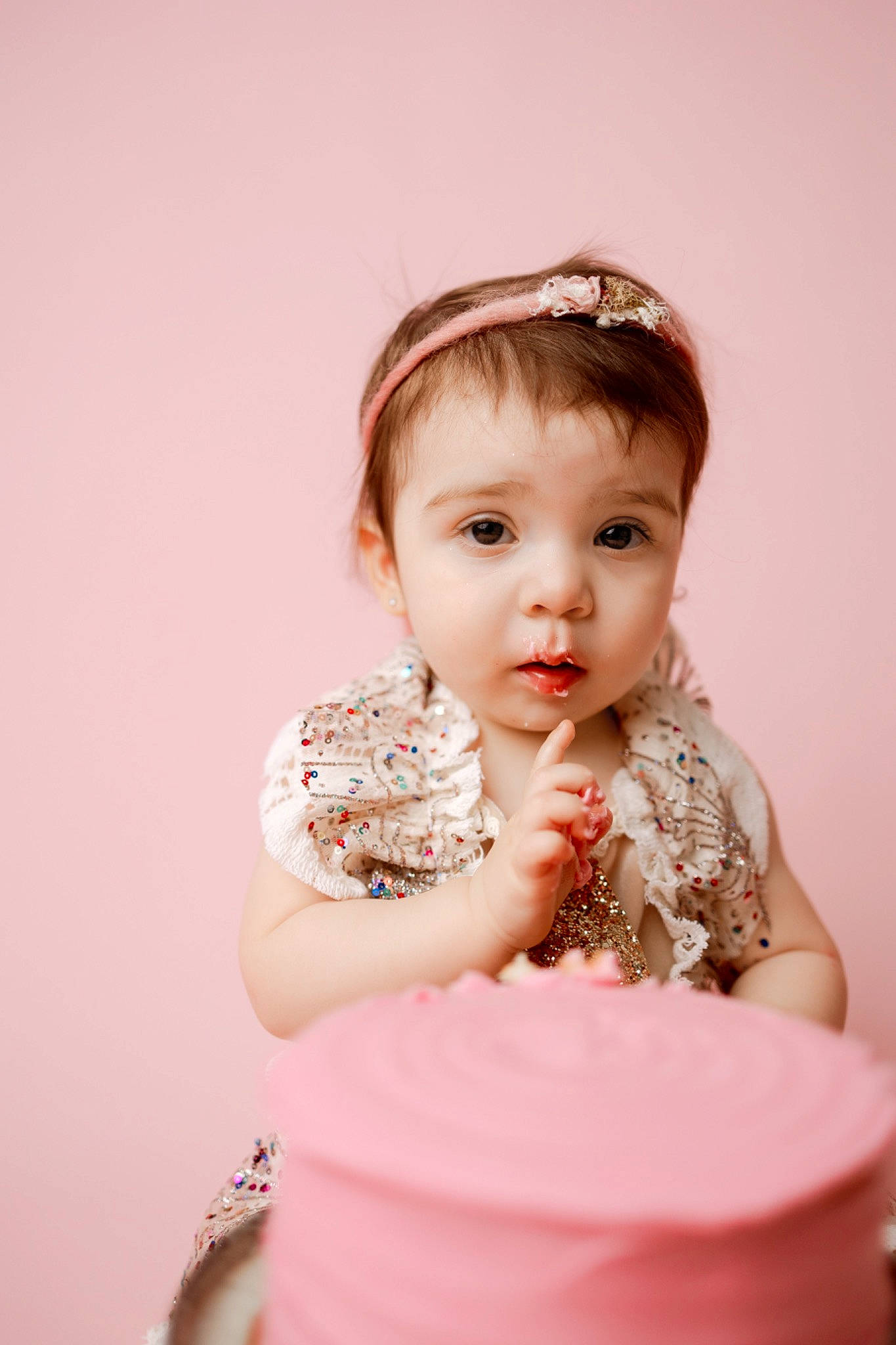 Liliana is registered to the contest to win money with this photo: baby_toddler_clothing, child, dress, embellishment, event, eyelash, face, fashion_accessory, flash_photography, hair, happy, head, headpiece, peach, person, pink, portrait_photography, sitting, sleeve, sweetness