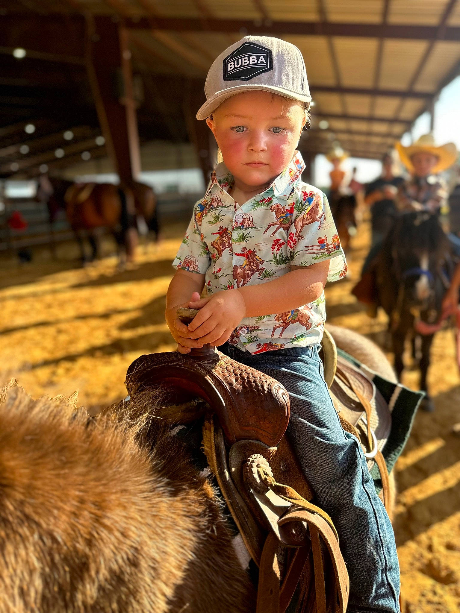 Jackson is registered to the contest to win money with this photo: baseball_cap, bridle, cap, child, event, fun, headwear, horse_tack, human, landscape, livestock, mammal, pack_animal, person, recreation, rein, sitting, soil, terrestrial_animal, toddler