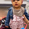 Athalia joined the competition — help win amazing prizes! baby, blurred_background, child, clothing, cute, denim_jacket, expression, face, fashion, footwear, hand_holding, indoor, person, pink_headband, portrait, ruffled_dress, soft_lighting, standing, toddler, young_child