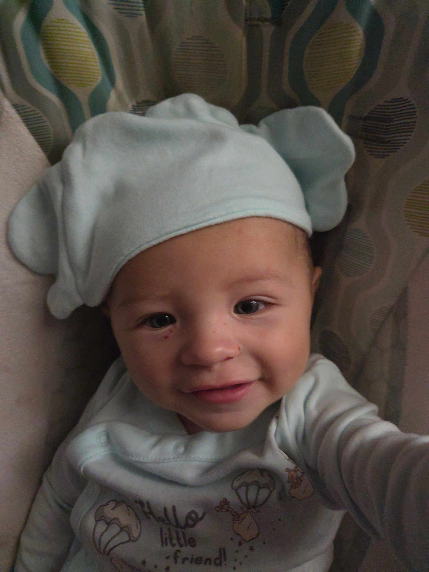 Liam joined the competition — help win amazing prizes! baby, child, smiling, hat, clothing, face, portrait, cute, infant, indoors, childrens_clothing, soft_toy, patterned_background, warm, happy, closeup, person, headwear, baby_garment, young_child
